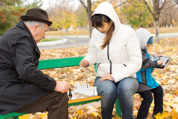 Aantrekkelijke vrouw Schaken met een oudere man — Stockfoto