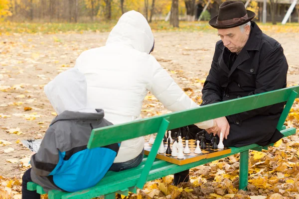 Grand-père jouant aux échecs avec sa fille — Photo