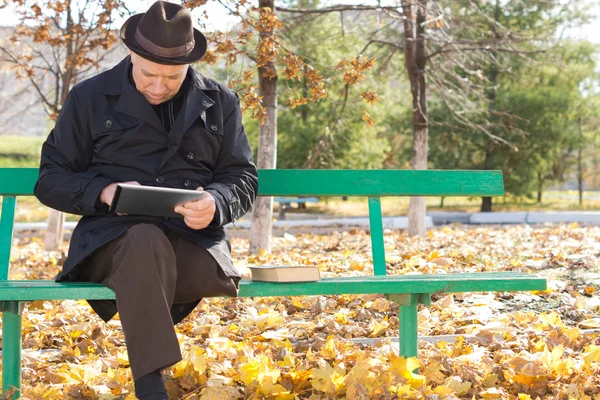 Homme âgé relaxant avec une tablette — Photo