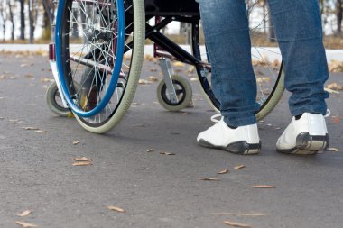 tekerlekli sandalye iterek kişi