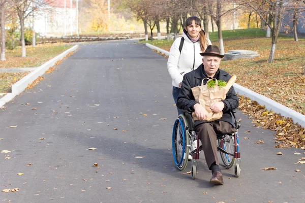 Starszy człowiek z opiekunem, kobiece niepełnosprawnych — Zdjęcie stockowe