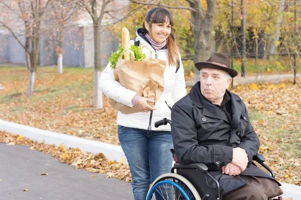 Kobieta pomaga niepełnosprawny mężczyzna z zakupy — Zdjęcie stockowe