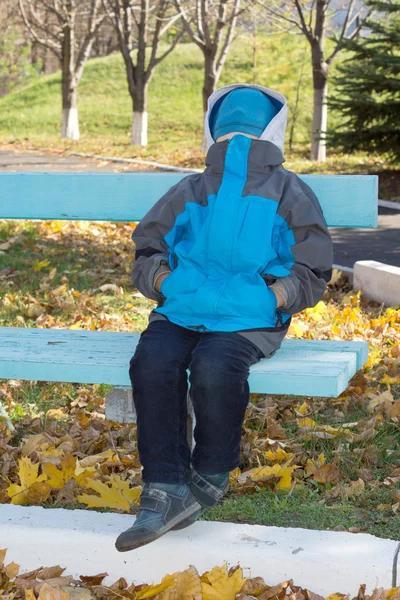 Kleine jongen zitten met een verborgen gezicht — Stockfoto