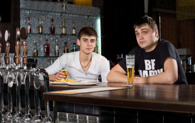 Two teenage men drinking at the pub clipart