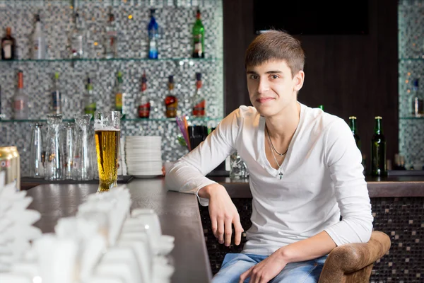 Friendly young man drinking in a bar — Stock Photo, Image