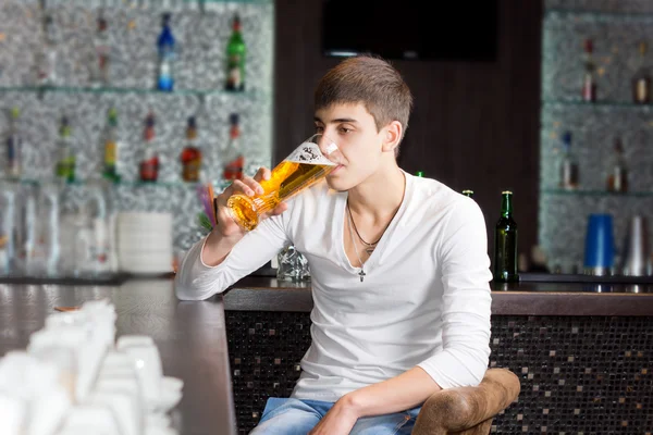 Young man drinking in a pub — Stock Photo, Image