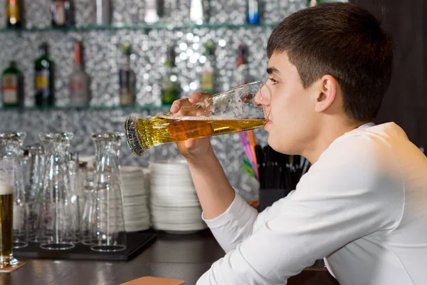 Young man drinking a pint of draught beer — Stock Photo, Image