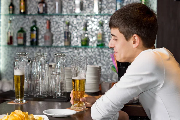 Genç adam bir bardak bira bir arkadaşıyla zevk — Stok fotoğraf