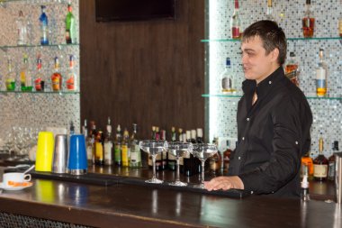 Alkollü kokteyller sunan barmen gülüyor