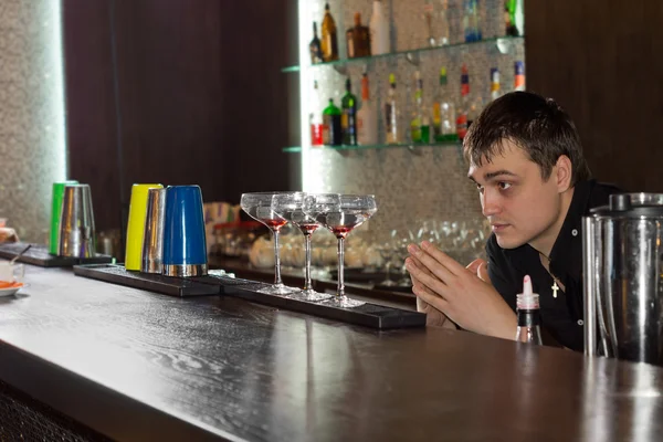 Barman verificando óculos alinhados no bar — Fotografia de Stock