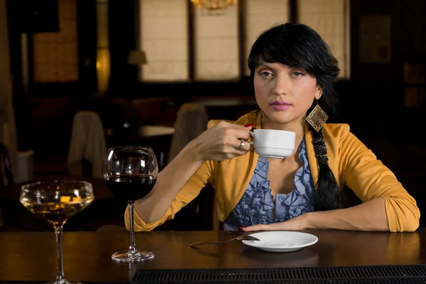 Žena pití kávy v baru čítač — Stock fotografie