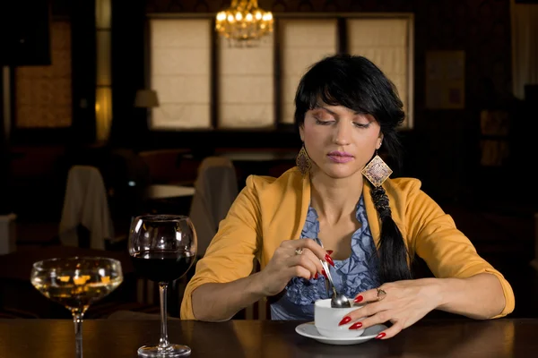 Kvinna sitter på en bar med kaffe — Stockfoto