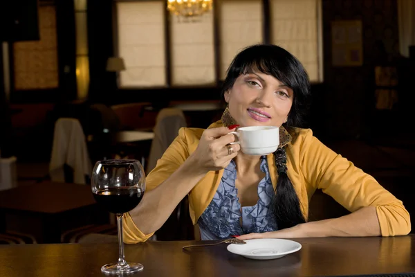 Kvinna avkopplande dricka kaffe i baren — Stockfoto