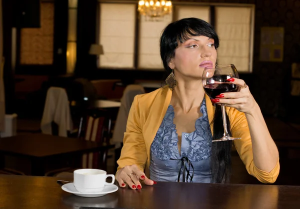 Mujer joven disfrutando del vino y el café — Foto de Stock