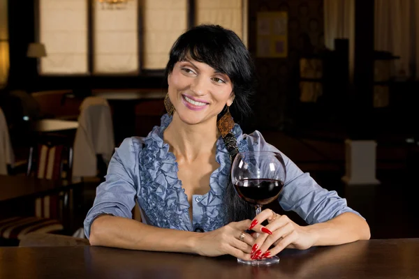 Kokette junge Frau trinkt in einer Bar — Stockfoto