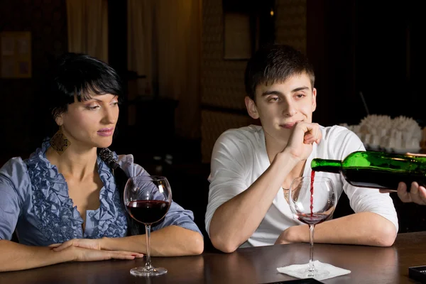 Barman derramando vinho assistido por um jovem casal — Fotografia de Stock