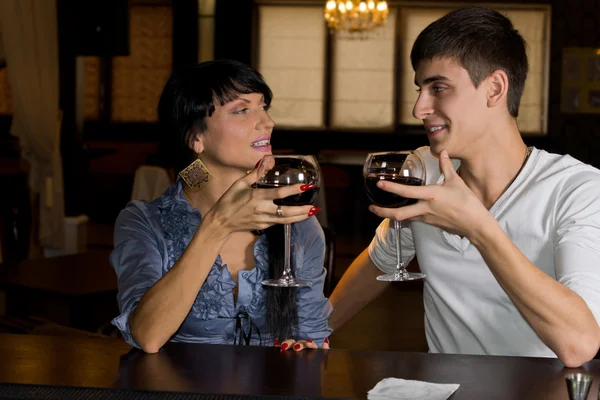 Junges Paar trinkt Rotwein an der Theke — Stockfoto