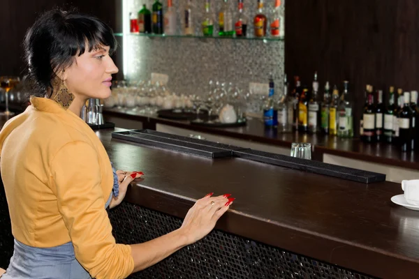 Young woman waiting for service at the bar counter — Stock Photo, Image