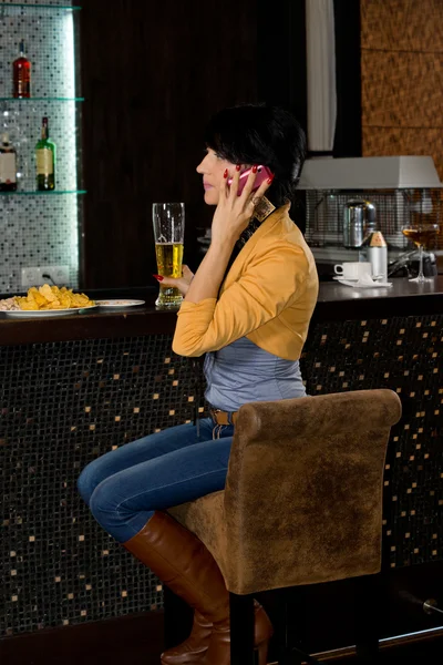 Mulher elegante sentado em um balcão de bar — Fotografia de Stock