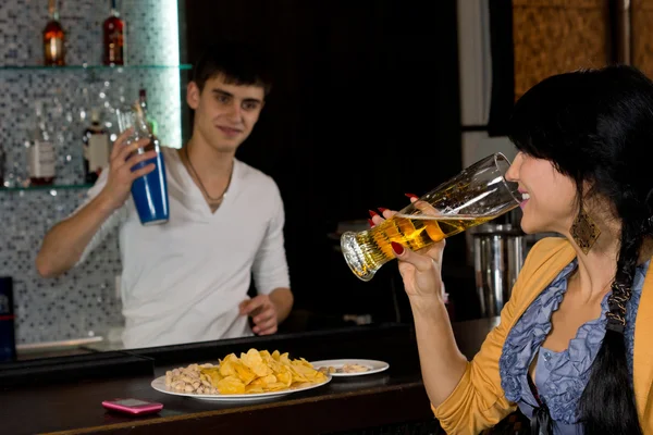 Jonge vrouw aan de barman chatten — Stockfoto