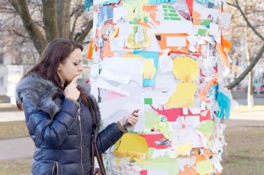 Woman reading a notice off a noticeboard clipart