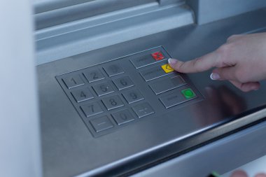 kadın bir banka atm üzerinde bir işlem seçmek