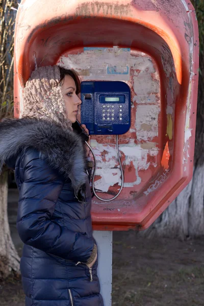 Młoda kobieta, za pomocą publicznych budki telefonicznej — Zdjęcie stockowe