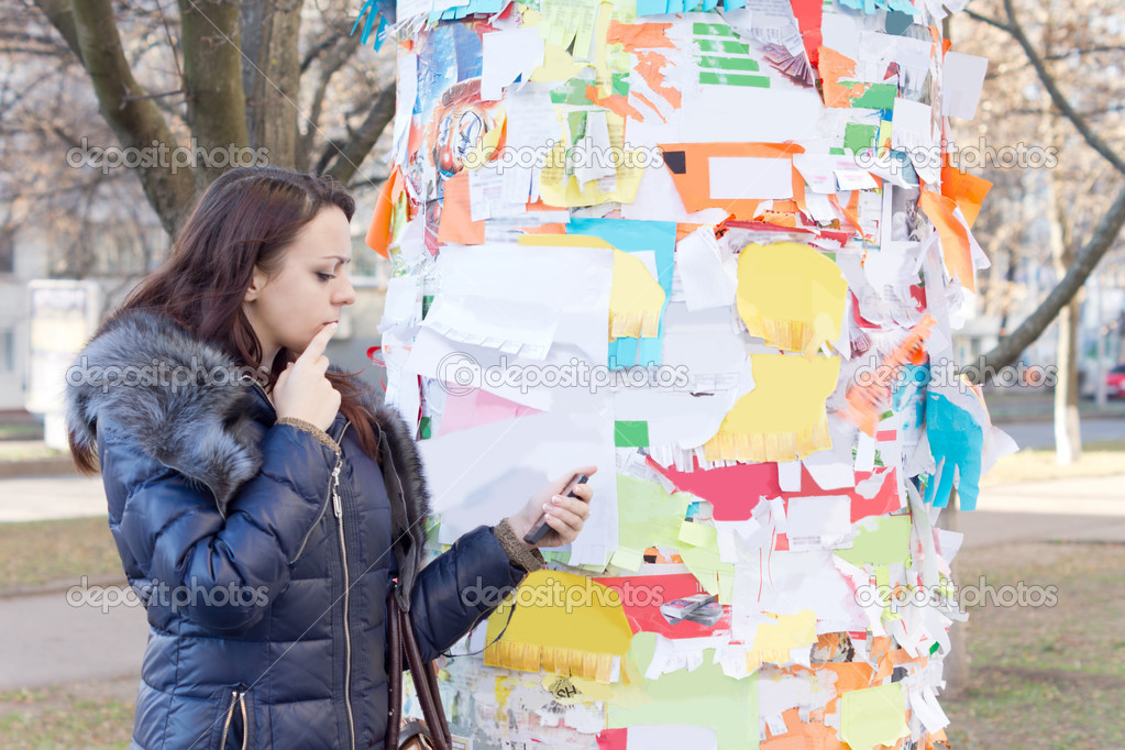 Woman reading a notice off a noticeboard