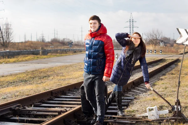 Verspieltes Paar wartet auf Zug mit Gepäck — Stockfoto