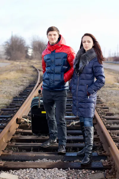 Impaciente jovem casal esperando nos trilhos do trem — Fotografia de Stock