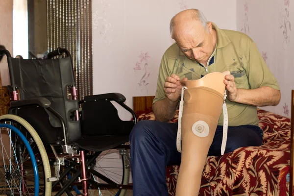 Старший мужчина проверяет чашку на протезной ноге — стоковое фото
