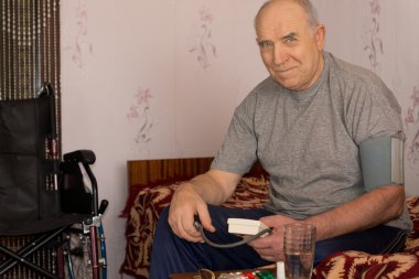 Kan basıncı alarak gülümseyen kıdemli adam