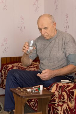 Unwell senior man taking medication clipart
