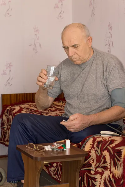 Unwell senior man taking medication — Stock Photo, Image