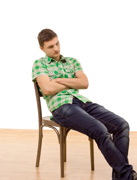 Handsome young man sitting slumped in a chair — Stock Photo, Image