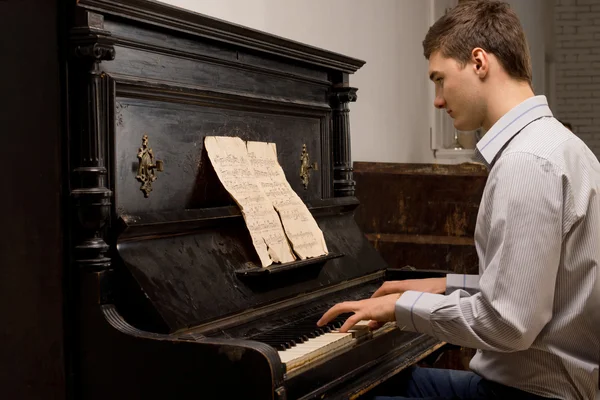 Young man practising at a piano — Stock Photo, Image