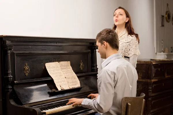 Jong koppel beoefenen van een muzikale duet — Stockfoto