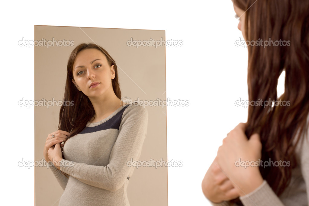 Young woman admiring herself in a mirror