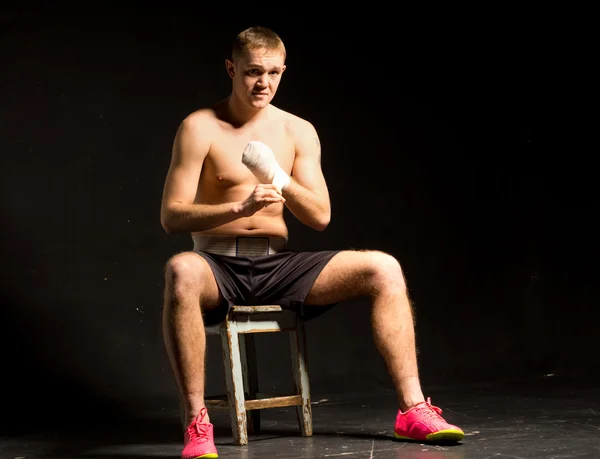 Muskulöser junger Boxer sitzt in seiner Ecke — Stockfoto