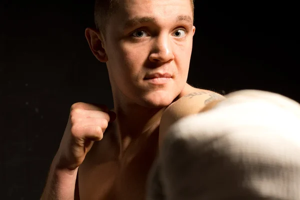 Młody mężczyzna bokser rzucanie punch — Zdjęcie stockowe