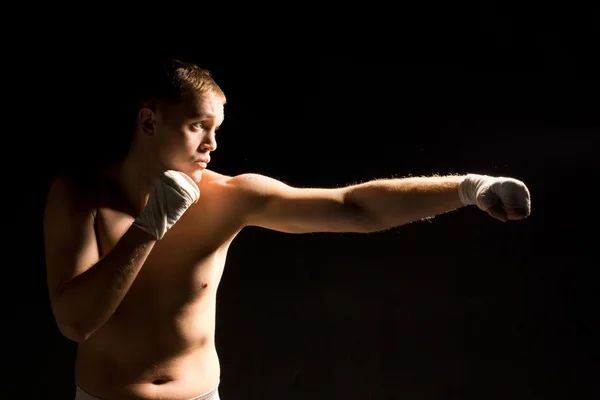 Determinado jovem boxeador dando um soco — Fotografia de Stock