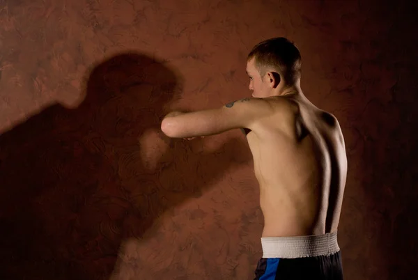 Young boxer fighting a shadowy opponent — Stock Photo, Image