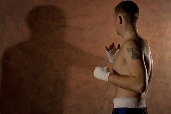 Boxeador con un tatuaje haciendo ejercicio en un gimnasio — Foto de Stock