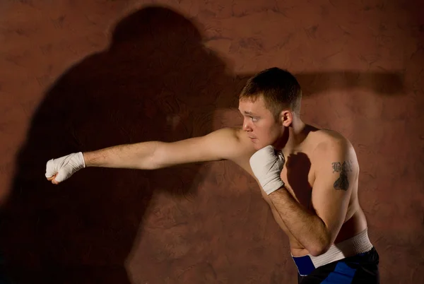 Joven boxeador golpeando a un oponente — Foto de Stock