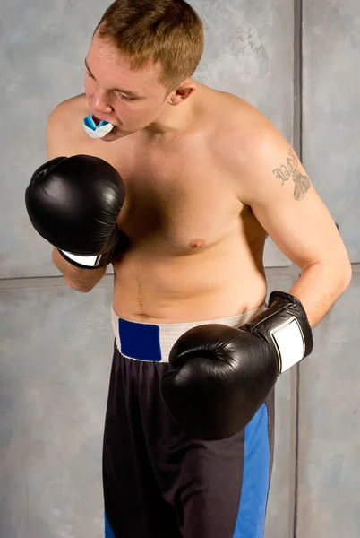 Jovem boxeador ajustando seu protetor bucal — Fotografia de Stock