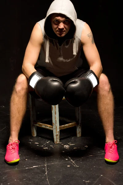 Boxer, sedí v rohu mezi koly — Stock fotografie