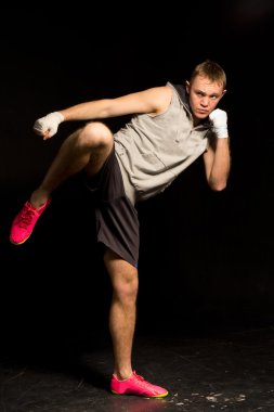 Athletic young kickboxer kicking during a fight clipart