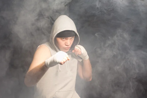 Young boxer fighting in a smoke filled atmosphere — Stock Photo, Image