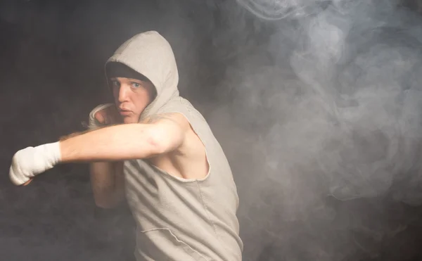 Young boxer throwing his weight behind a punch — Stock Photo, Image