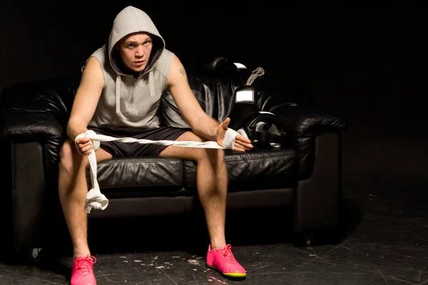 Thoughtful young boxer bandaging his hands — Stock Photo, Image